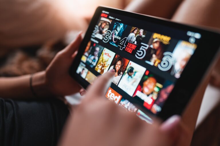 Person streamt Videos auf einem Tablet-Bildschirm